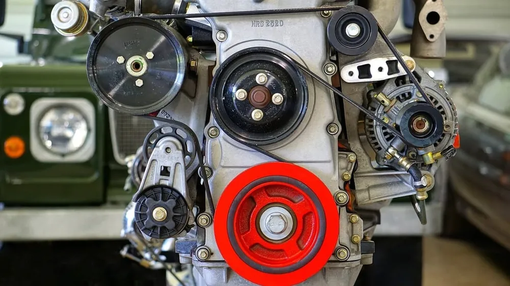 Automotive V belt driving engine pulleys in a vehicle engine